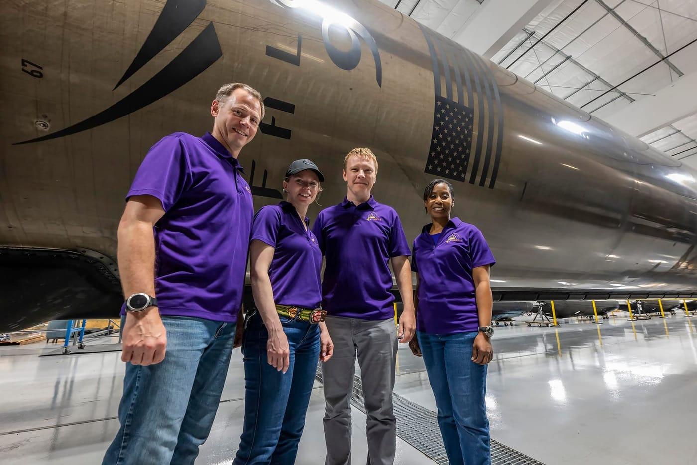 NASA’s SpaceX Crew-9 members stand in front of a Falcon 9 first-stage booster
